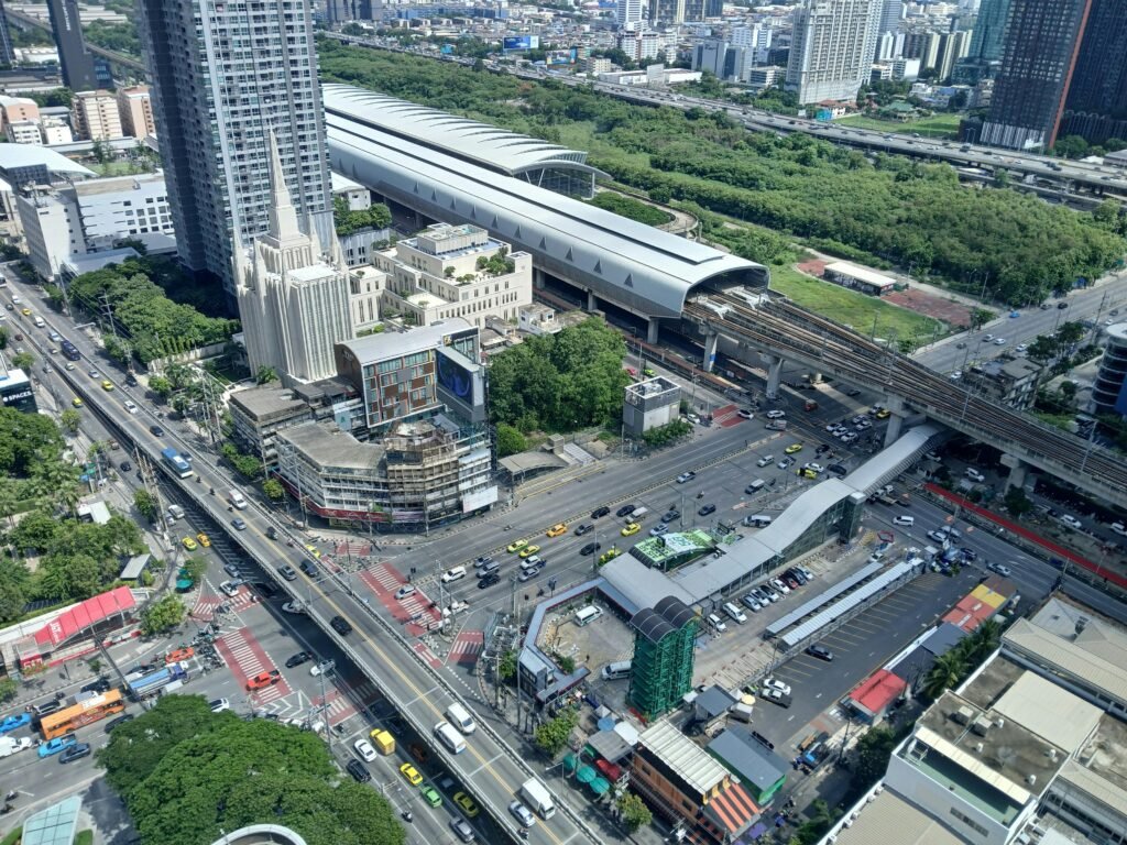 pexels-photo-32265023-32265023 Aerial view of a bustling city intersection and a modern train station with surrounding skyscrapers.